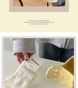 Detail of white combed cotton socks featuring a vertical ribbed texture and minimalist design