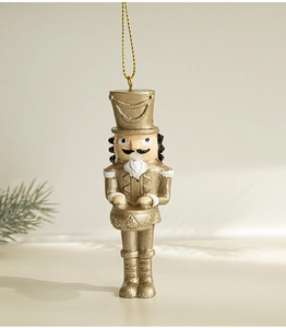 Detailed view of a golden Nutcracker Christmas ornament hanging with pine needle decor