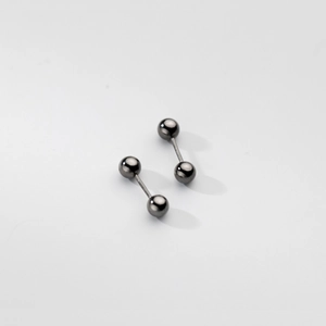 Vue macro des boucles d'oreilles barbell minimalistes en métal noir poli et brillant