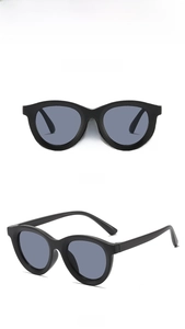 Detail view of stylish black cat-eye kids sunglasses with grey lenses and glossy finish