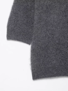 Detail of dark grey knit polo sweater showing plush mohair texture and ribbed cuffs