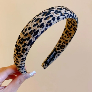 Detail of leopard print fabric headband featuring a hand-made label and soft cloth texture