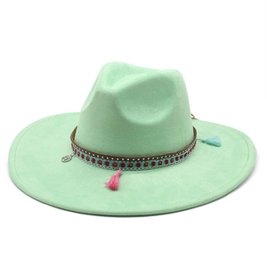 Detail of mint green fedora hat featuring ethnic ribbon with floral pattern and tassels