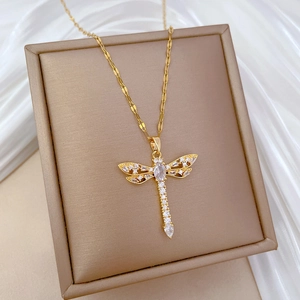 Elegant gold titanium dragonfly necklace with zircon crystal pendant on silk backdrop