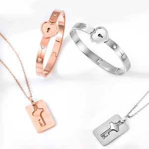 Detail of interlocking heart lock bracelets and key necklaces in rose gold and silver