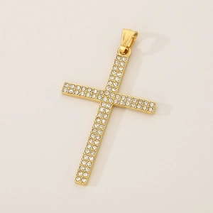 Macro shot of gold cross pendant with pavé set crystals and shiny metallic details