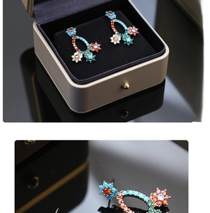 Macro view of multi-color zircon flower earrings with S925 silver needles on jewelry box