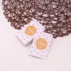 Macro detail of thick greeting card with pink dots and orange circle featuring Hello text