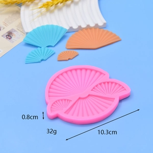 Macro shot of fan-shaped pink silicone mold with detailed fondant textures on blue background