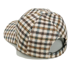 Detailed close-up of wool texture and classic check pattern on the beige baseball cap