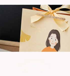 Detail of teacher appreciation gift bag with ribbon and cartoon illustration
