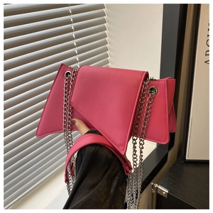Detail of hot pink asymmetrical chain bag with silver hardware and smooth leather finish
