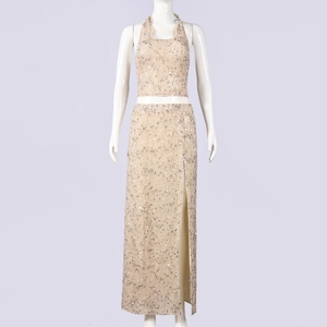 Dettaglio del set crop top con paillettes oro champagne e gonna lunga con spacco