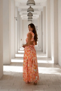 Floral maxi dress detail showing backless design and vibrant orange-pink floral patterns