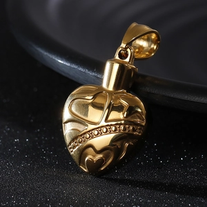 Macro shot of gold heart-shaped memorial locket pendant with intricate floral engravings