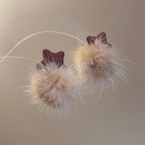 Macro shot of light brown plush balls with dark brown star fabric bases for earrings