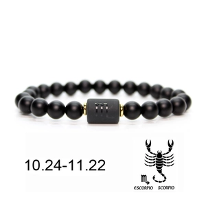 Detailed macro view of black matte beaded Scorpio bracelet with cylindrical zodiac charm