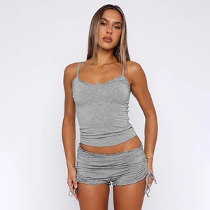 Detailed close-up of grey knit camisole set featuring side drawstrings and ruffle hem shorts