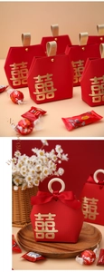 Detail of red wedding candy boxes with leather handles and gold Double Happiness foil stamp