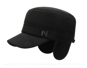 Detail of a black winter army cap featuring a metal N logo and foldable ear flaps