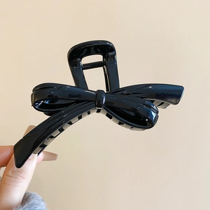 Close-up of a large black 3D bow hair claw clip made of high-gloss resin material