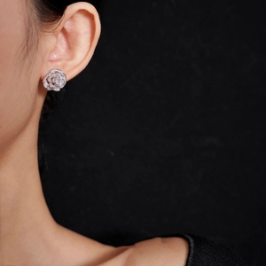 Détail d'un ear cuff camélia argenté avec zircons porté par un mannequin