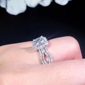 Macro detail of square-cut halo engagement ring with double-row diamond-set band