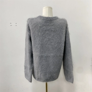 Dettaglio della texture in peluche a pelo lungo su un maglione grigio a maniche lunghe