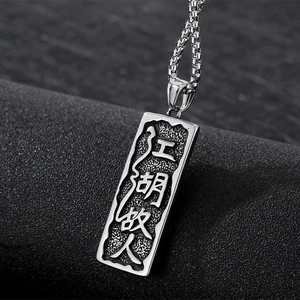 Détail macro du pendentif punk en argent avec relief chinois sur fond noir texturé