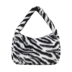 Fashionable zebra print plush hobo bag with a minimalist crescent shape and soft texture