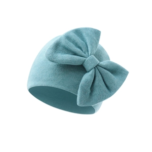 Detail of soft ribbed knit texture and decorative bow on light blue baby beanie hat