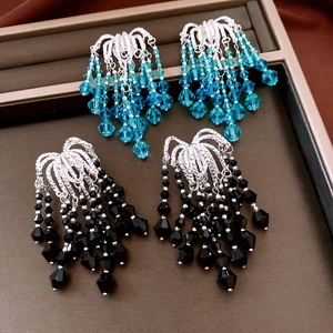 Detailed view of glass bead tassel earrings in blue and black on jewelry tray