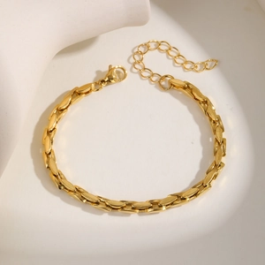 Close-up of gold stainless steel flat oval link bracelet with lobster clasp detail