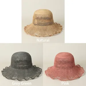 Three colors of raffia sun hats with wavy brims in natural, grey-green, and pink shades