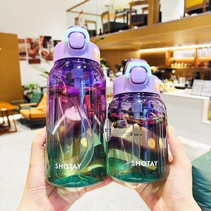 Close-up of purple and green gradient Tritan water bottles held in a cafe setting