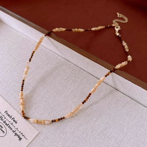 Close-up of a floral tiger eye stone beaded necklace with a golden adjustable chain