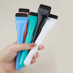 Detailed close-up showing five colorful flat foundation brushes held for size reference