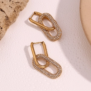 Macro detail of 18K gold plated interlocking oval earrings with micro-set zircons