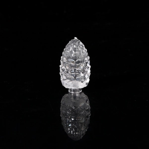 Close-up of transparent crystal pinecone LED light accessory on black mirror surface