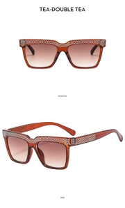 Detailed macro view showing the amber tea frame with sparkling crystal rhinestones and gradient lenses