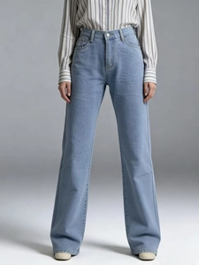 Detail view of high waist stitching and pocket structure on light blue denim jeans