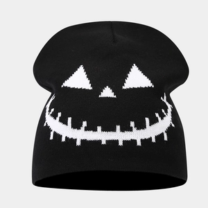 Detailed view of white ghost face pattern knitted on a black winter beanie hat