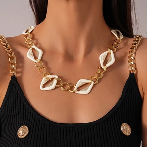 Détail du collier chaîne dorée avec des breloques en forme de losange serties de zircons