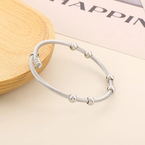Detail view of adjustable silver cable wire bracelet with six polished metal beads