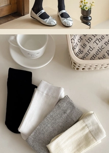 Close-up of ribbed cotton socks in four neutral colors with ballet-style footwear