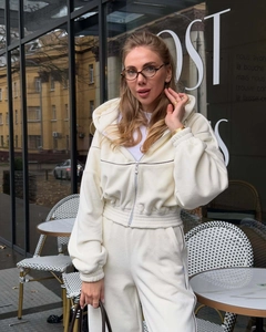 Détail d'un ensemble de sport en polaire blanc crème avec sweat à capuche court zippé