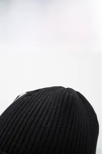 Close-up of thick black ribbed knit beanie showing warm thermal texture and weave