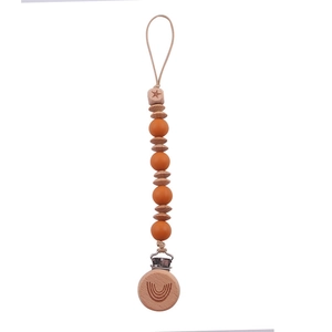Detail of wooden beech pacifier clip with orange silicone beads and rainbow engraving