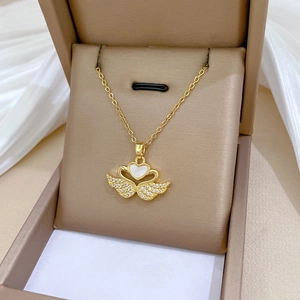 Close-up of golden swan heart necklace with sparkling crystals and mother of pearl inlay