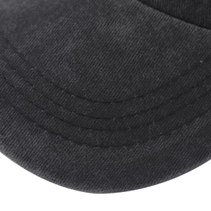 Macro shot of durable triple-stitched seams on a washed black cotton baseball cap brim